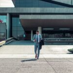 man walking while holding black coat